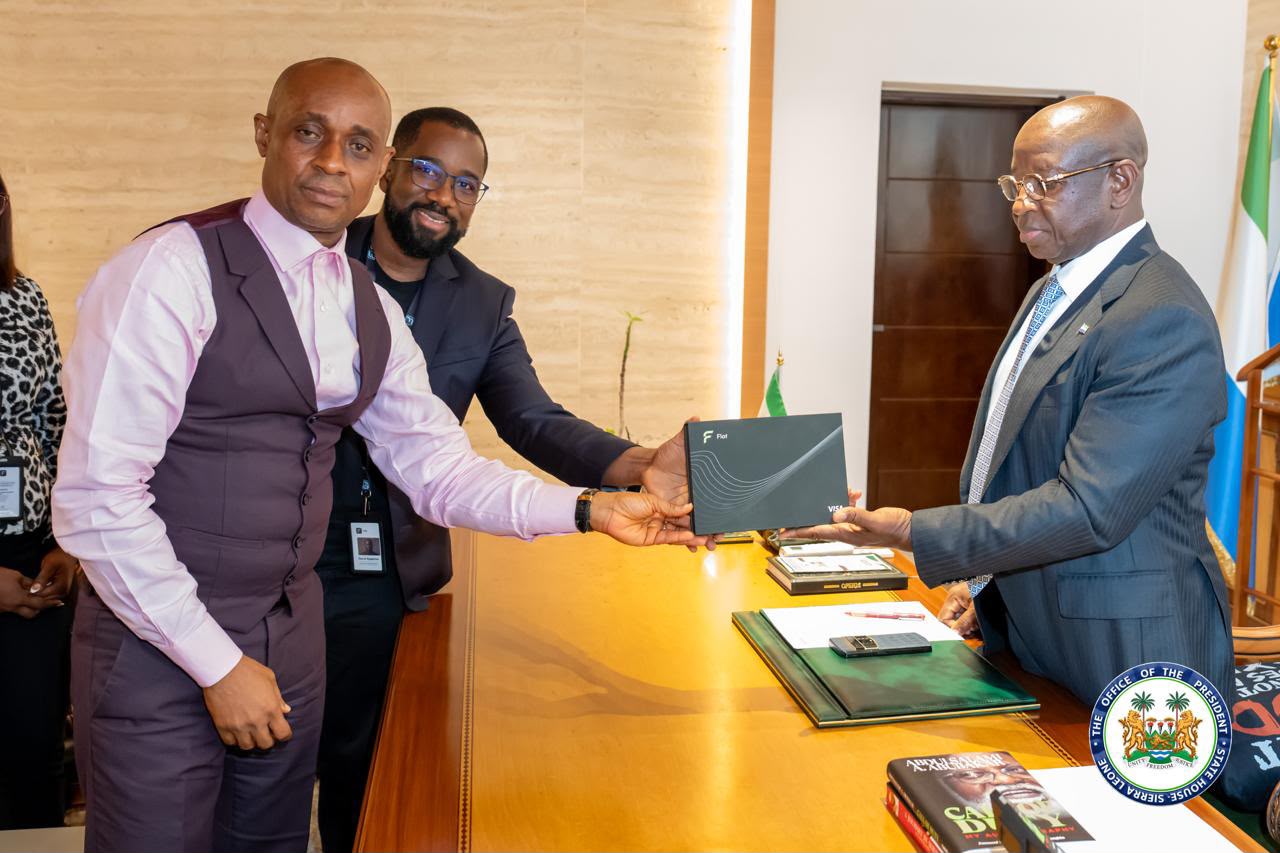 President Bio receives the Flot card presentation box during the team's visit to State House.